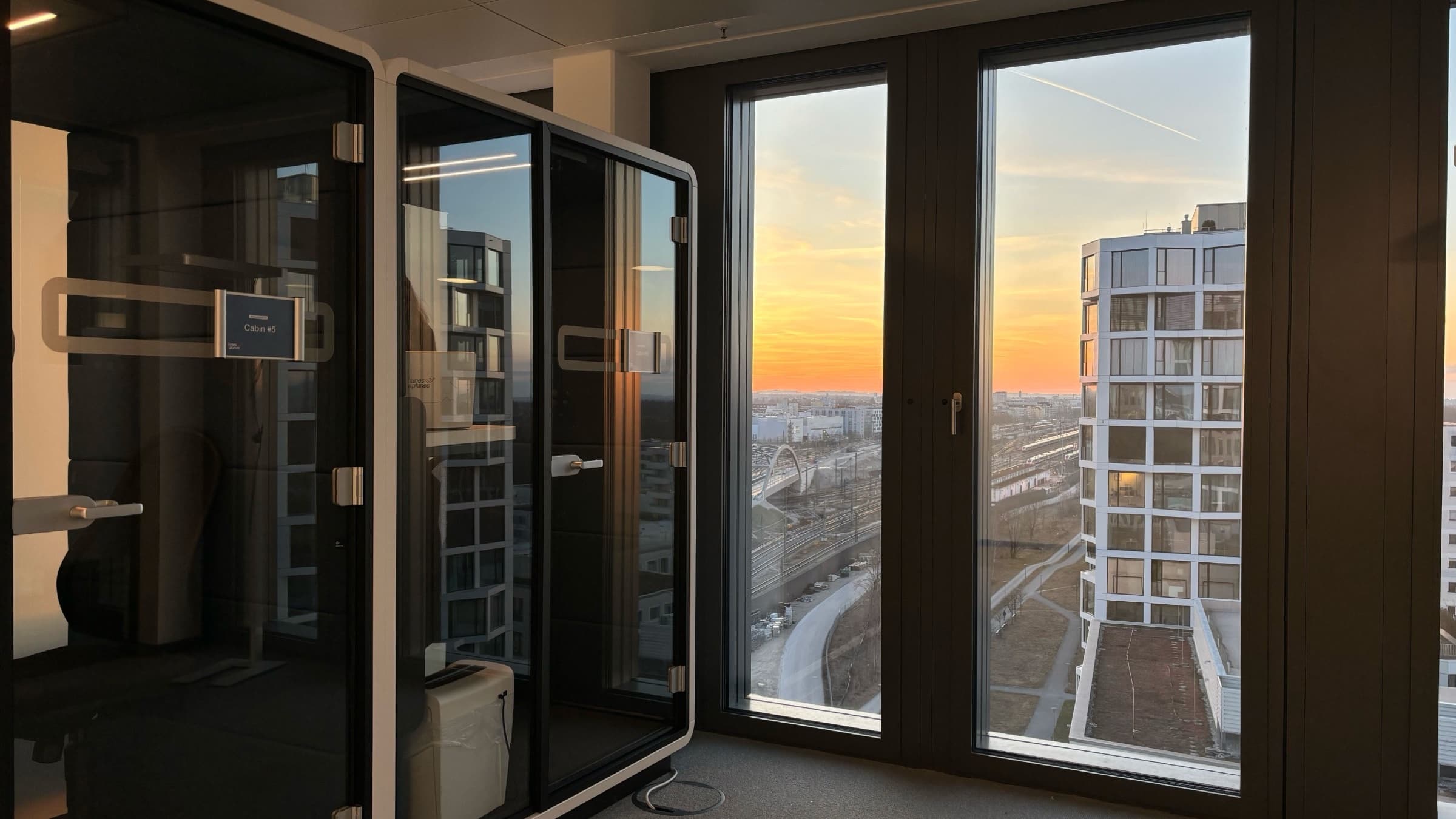 Lanes & Planes Büro mit Telefonkabinen und Blick auf den Sonnenuntergang